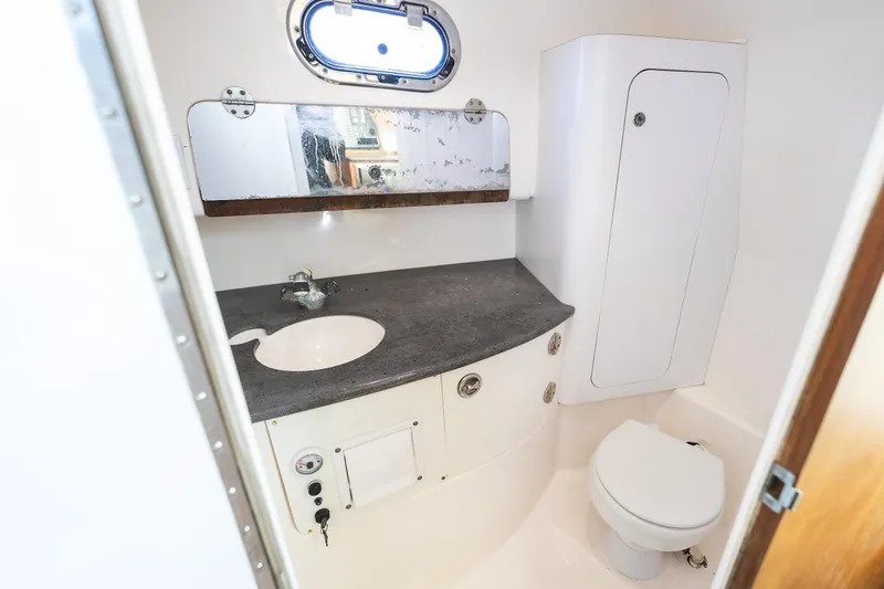 Slide: The Image of Compact boat bathroom with sink, mirror, and toilet in 2011 Everglades 350EX model. - 18