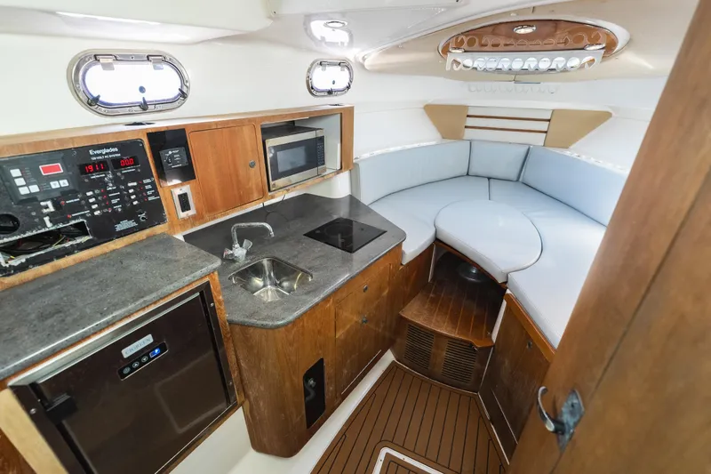 Slide: The Image of Interior of 2011 Everglades 350EX boat with kitchenette and seating area. - 19