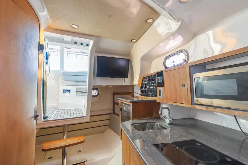 Slide: The Image of Interior of 2011 Everglades 350EX boat with kitchenette, TV, and control panel. - 20