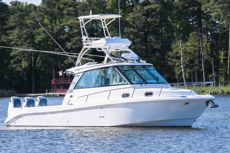 Slide: The Image of 2011 Everglades 350EX boat on calm water with forest backdrop. - 3
