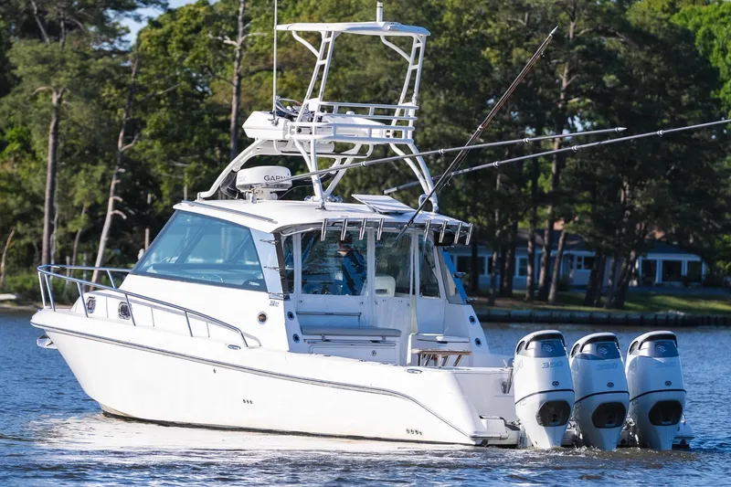 Slide: The Image of 2011 Everglades 350EX boat on calm water with trees in the background. - 5