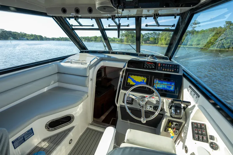 Slide: The Image of Cockpit of 2011 Everglades 350EX boat with navigation screens and steering wheel on a serene lake. - 6