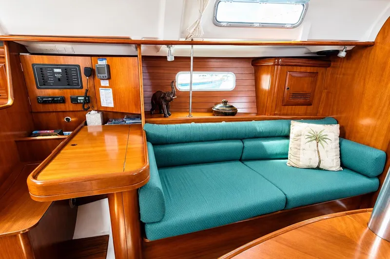 Slide: The Image of Interior of 2001 Beneteau 361 yacht with teal sofa and wooden cabinetry. - 11