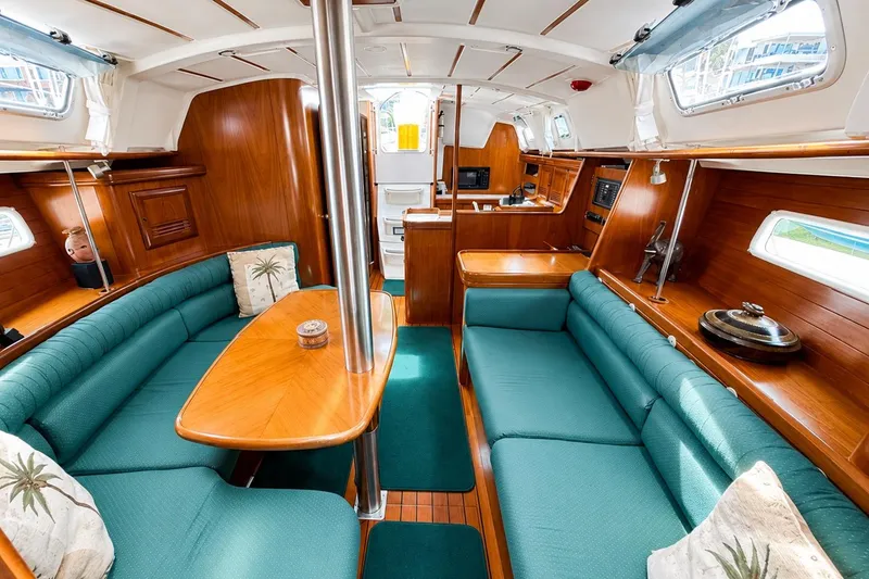 Slide: The Image of Interior of a 2001 Beneteau 361 sailboat with teal seating and wooden finishes. - 12