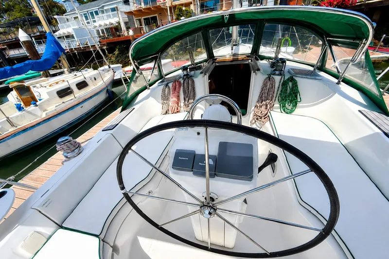 Slide: The Image of Cockpit view of a 2001 Beneteau 361 sailboat with green canopy and steering wheel. - 5
