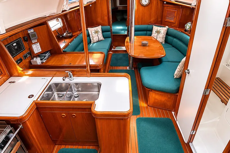 Slide: The Image of Interior of 2001 Beneteau 361 yacht with wood finish and teal seating. - 9