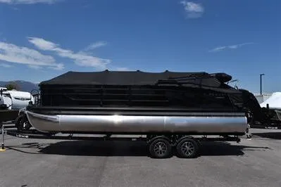 The Image of 2026 Lowe SF 232 Sport Fish pontoon boat on trailer under clear blue sky. - 0
