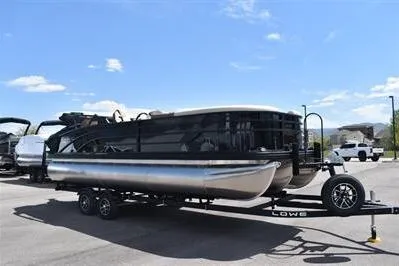Slide: The Image of 2026 Lowe SF 232 Sport Fish pontoon boat on trailer under clear blue sky. - 11