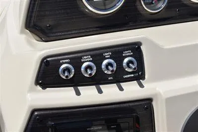 Slide: The Image of Control panel of 2026 Lowe SF 232 Sport Fish boat with switches for stereo and lights. - 32