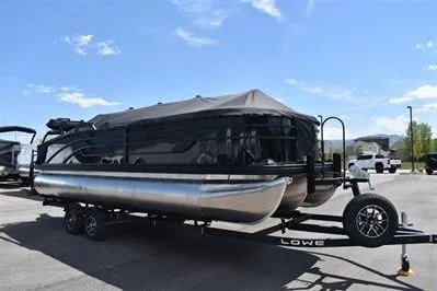 Slide: The Image of 2026 Lowe SF 232 Sport Fish pontoon boat on trailer under clear blue sky. - 5