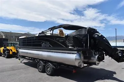 Slide: The Image of 2026 Lowe SF 232 Sport Fish pontoon boat on trailer, parked outdoors under blue sky. - 8