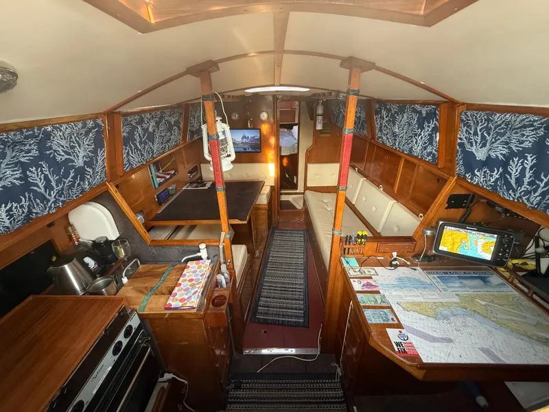 Slide: The Image of Interior of a 1980 Rival 32 yacht with maps and wooden furnishings. - 15
