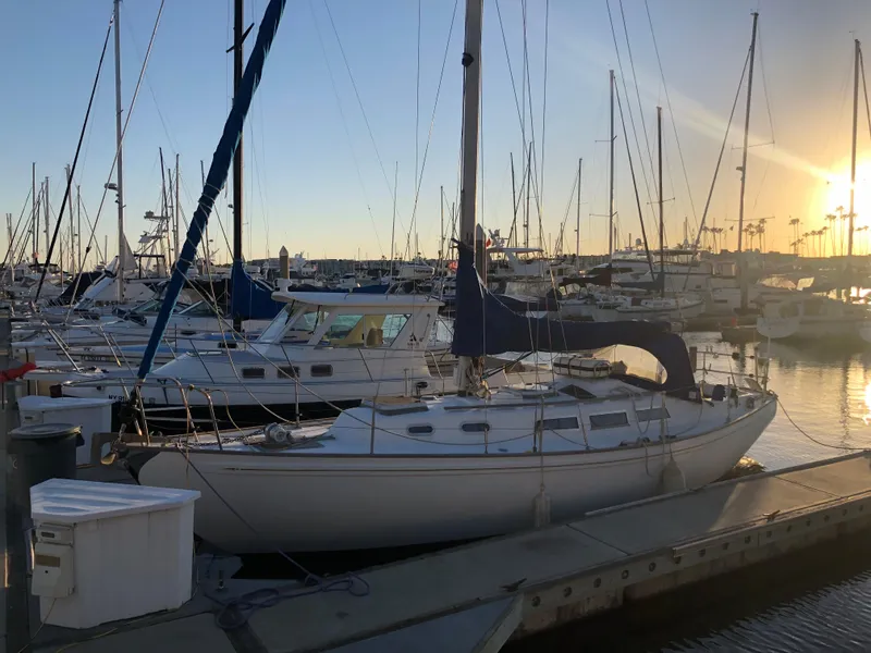 Slide: The Image of 1980 Rival 32 sailboat docked at marina during sunset. - 3