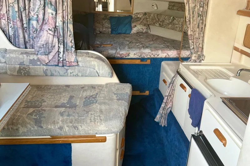 Slide: The Image of Interior of 1992 Sea Ray 290 Sundancer boat with cozy seating and kitchenette. - 10