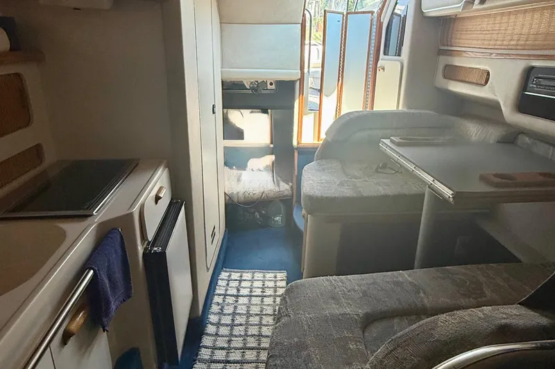 Slide: The Image of Interior of 1992 Sea Ray 290 Sundancer boat with kitchenette and seating area. - 11