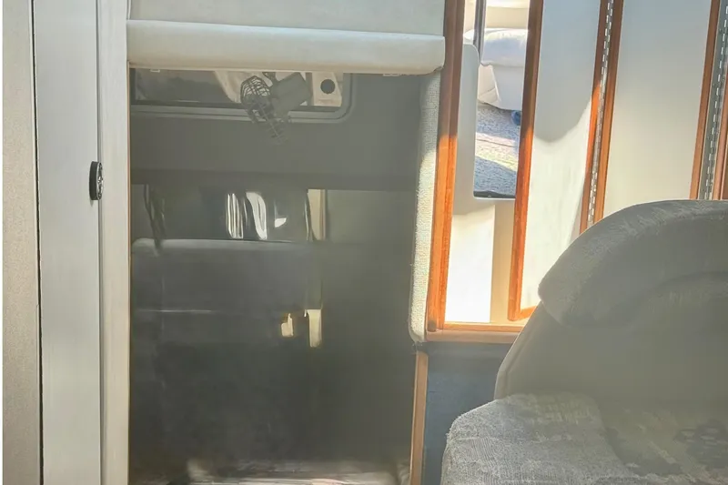 Slide: The Image of Interior view of a 1992 Sea Ray 290 Sundancer cabin with seating and wood accents. - 15