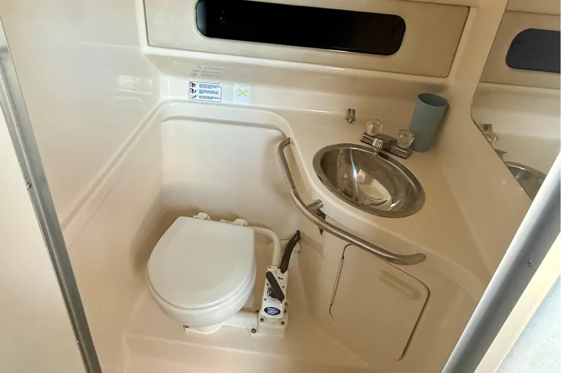 Slide: The Image of 1992 Sea Ray 290 Sundancer bathroom with toilet and sink. - 18