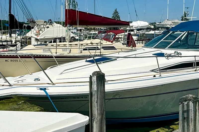 Slide: The Image of 1992 Sea Ray 290 Sundancer docked at a marina, surrounded by other boats. - 2