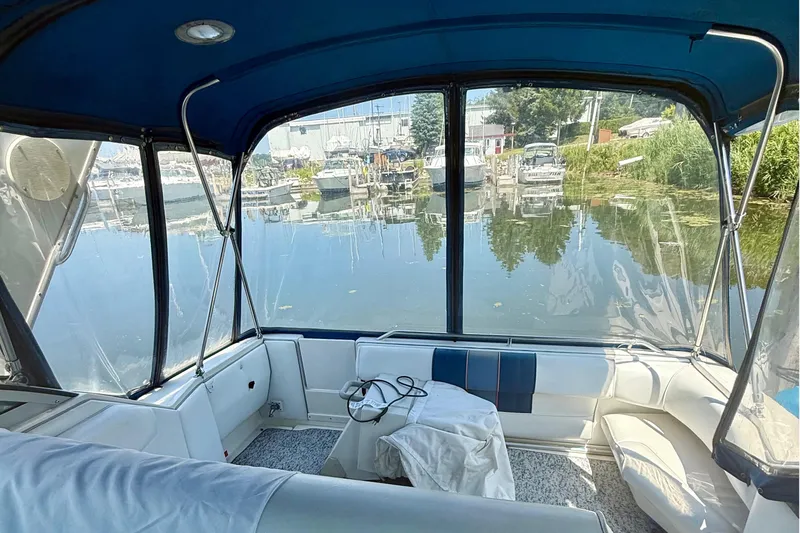 Slide: The Image of Interior view of 1992 Sea Ray 290 Sundancer boat with marina backdrop. - 6