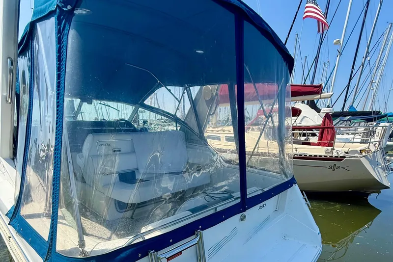 Slide: The Image of 1992 Sea Ray 290 Sundancer boat docked with clear canopy and American flag. - 7