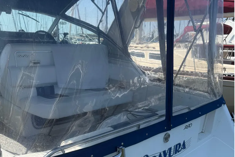 Slide: The Image of 1992 Sea Ray 290 Sundancer boat with clear enclosure and white seating in marina. - 8