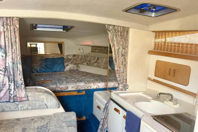 Slide: The Image of Interior of a 1992 Sea Ray 290 Sundancer boat with cozy sleeping area and kitchenette. - 9