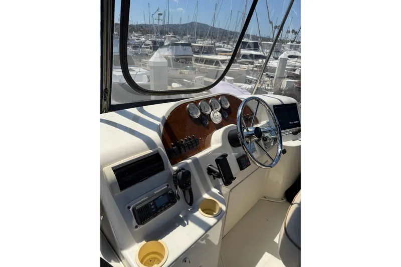Slide: The Image of 2007 Silverton 33 Convertible boat helm with gauges and steering wheel in marina setting. - 11