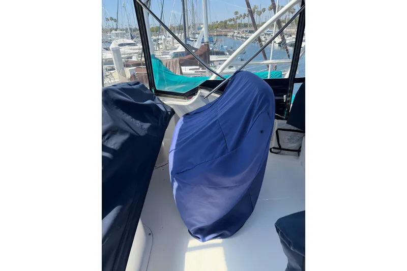 Slide: The Image of 2007 Silverton 33 Convertible boat interior with covered seating in a marina setting. - 16