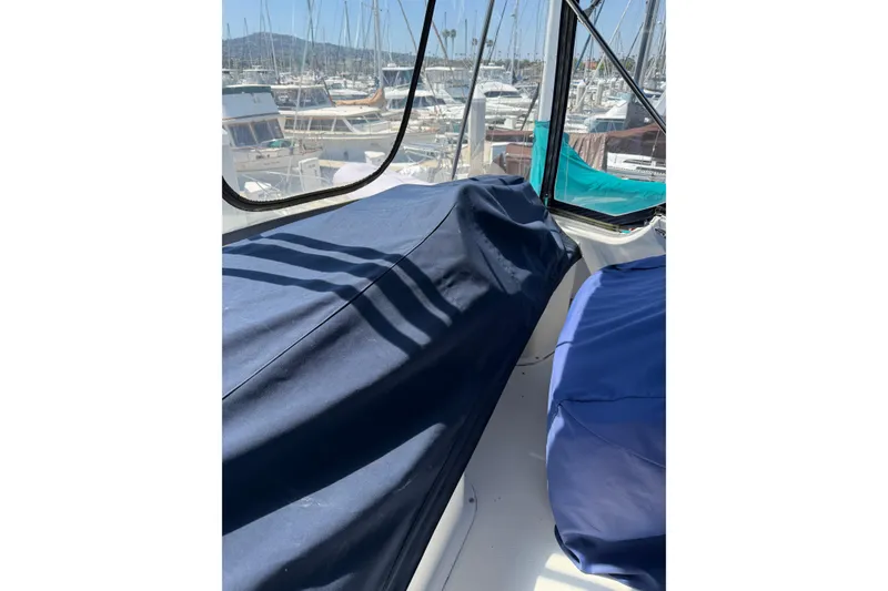 Slide: The Image of 2007 Silverton 33 Convertible boat interior with blue covers, docked at a marina. - 17