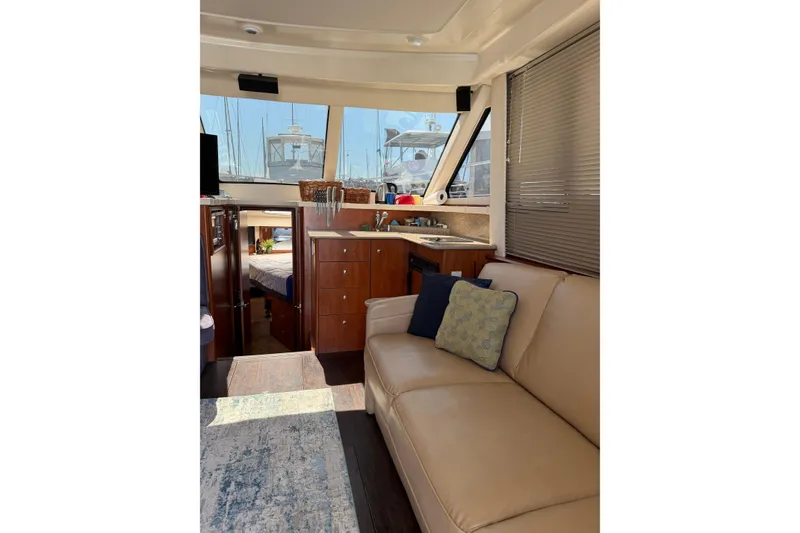 Slide: The Image of Interior of 2007 Silverton 33 Convertible yacht with beige seating and wooden cabinetry. - 19