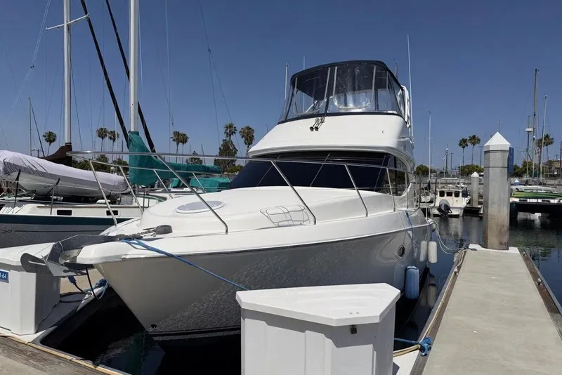 Slide: The Image of 2007 Silverton 33 Convertible yacht docked at marina under clear blue sky. - 2