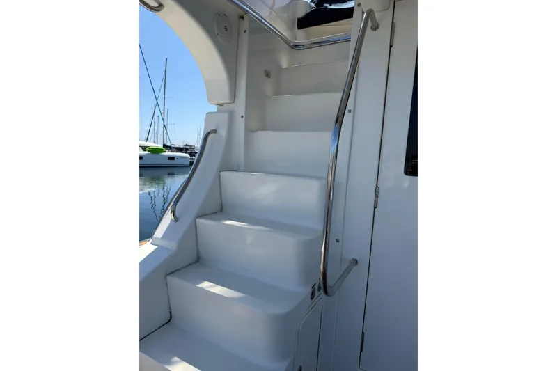 Slide: The Image of Staircase on 2007 Silverton 33 Convertible yacht with sleek white design and metal handrails. - 4