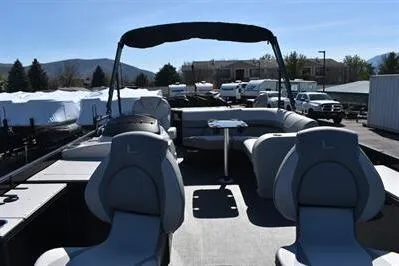 Slide: The Image of 2026 Lowe SF 214 Sport Fish pontoon boat with spacious seating and canopy, parked outdoors. - 16