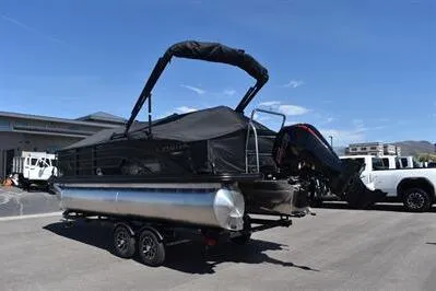 Slide: The Image of 2026 Lowe SF 214 Sport Fish pontoon boat on trailer, parked outdoors. - 2