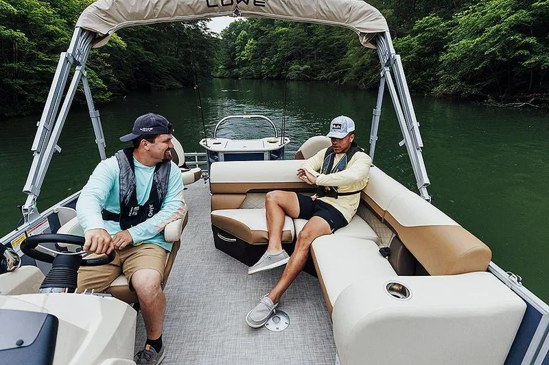 Slide: The Image of Manufacturer Provided Image: Two people relaxing on a 2025 Lowe SF 214 boat in a lush river setting. - 44