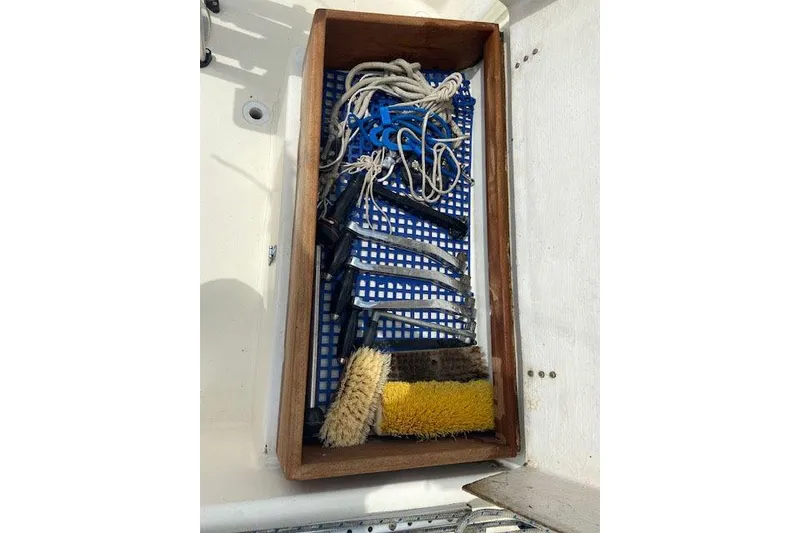 Slide: The Image of Wooden storage box with ropes, brushes, and tools on a 1977 C&C 29 sailboat. - 13