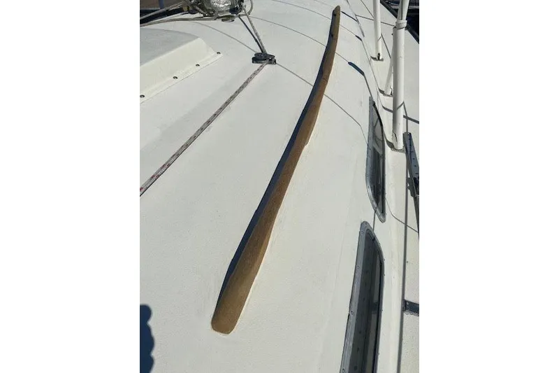 Slide: The Image of 1977 C&C 29 sailboat deck with wooden handrail and cabin windows. - 2