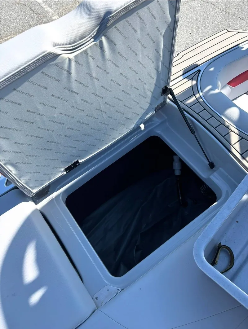 Slide: The Image of Open storage compartment on a 2022 MasterCraft XT23 boat. - 14