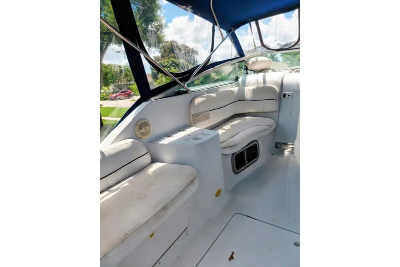 Slide: The Image of Interior of a 2000 Crownline 242 CR boat with white seating and blue canopy. - 11