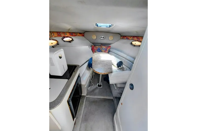 Slide: The Image of Interior of 2000 Crownline 242 CR boat with seating and compact kitchenette. - 14