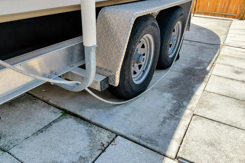 Slide: The Image of Trailer wheels of a 2000 Crownline 242 CR boat parked on concrete. - 20