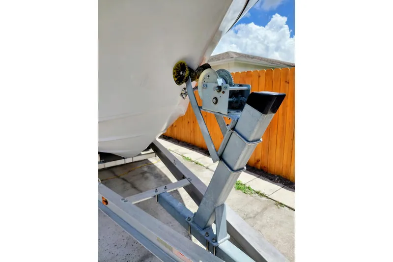 Slide: The Image of Trailer winch of a 2000 Crownline 242 CR boat, parked on a driveway. - 22