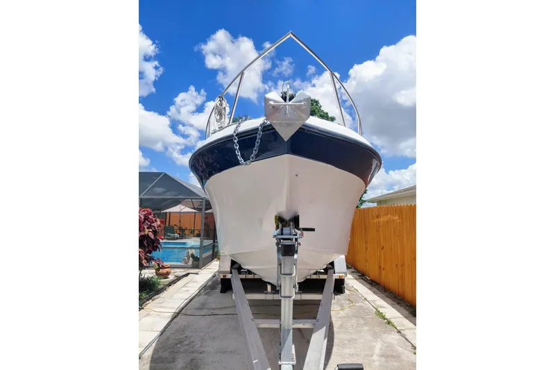 Slide: The Image of 2000 Crownline 242 CR boat on trailer under a bright blue sky. - 3