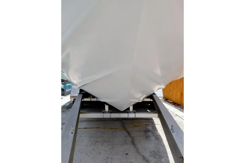 Slide: The Image of 2000 Crownline 242 CR boat on trailer, viewed from the front, in a driveway. - 4