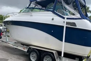 Slide: The Image of 2000 Crownline 242 CR boat on trailer, blue and white design, parked outdoors. - 8