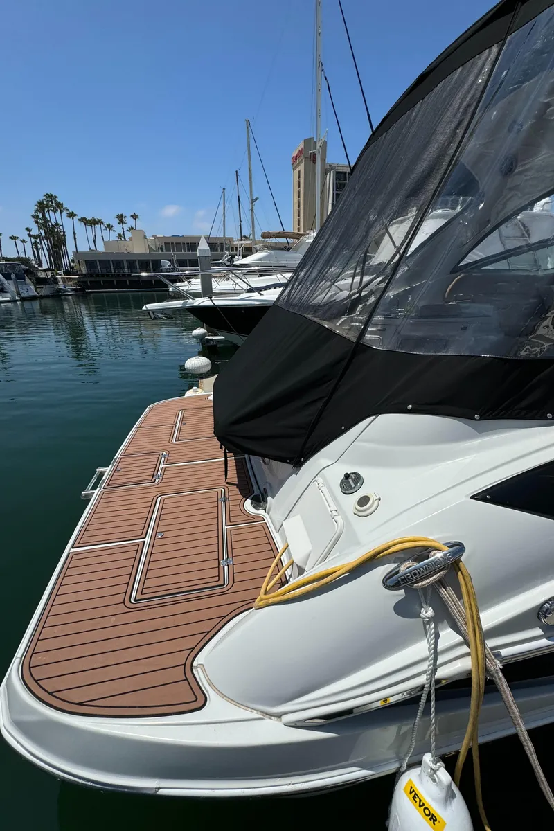 Slide: The Image of 2018 Crownline 350 SY yacht docked in marina, featuring sleek design and spacious deck. - 18