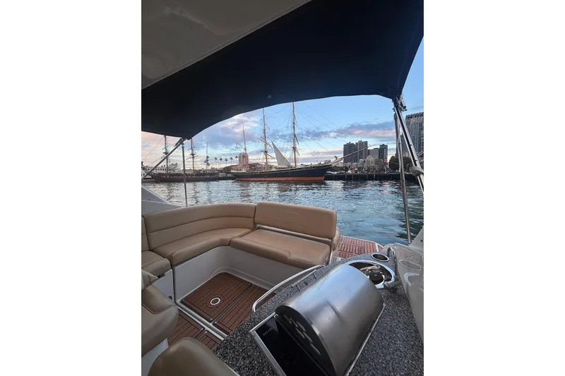 Slide: The Image of 2018 Crownline 350 SY boat interior with city skyline and sailing ship in background. - 20