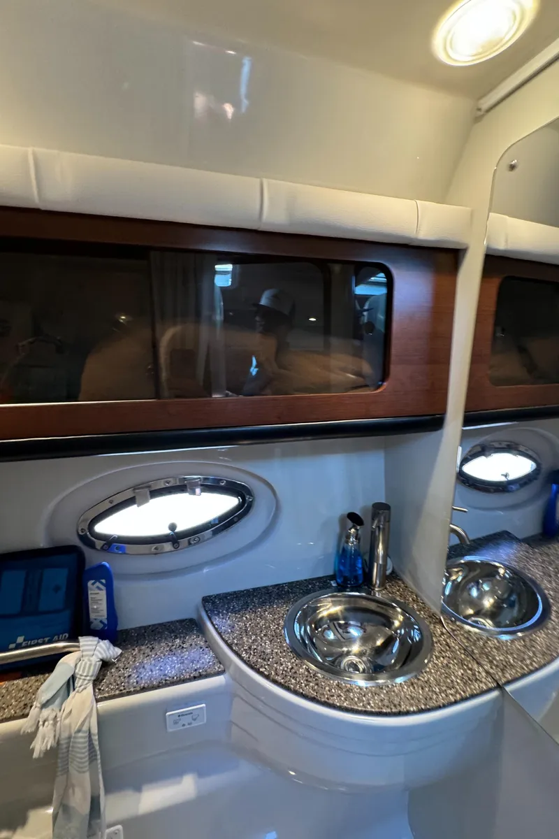 Slide: The Image of Interior of 2018 Crownline 350 SY yacht bathroom with modern sink and porthole window. - 25
