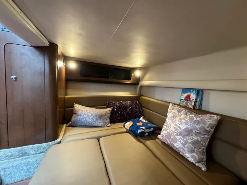 Slide: The Image of 2018 Crownline 350 SY cabin interior with cozy seating and decorative pillows. - 41