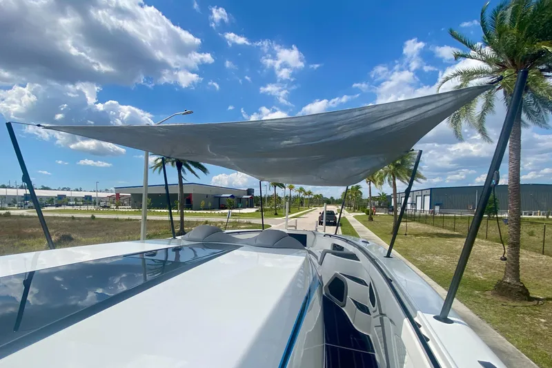 Slide: The Image of 2024 MTI V50 boat with sunshade, parked under a clear blue sky with palm trees. - 30